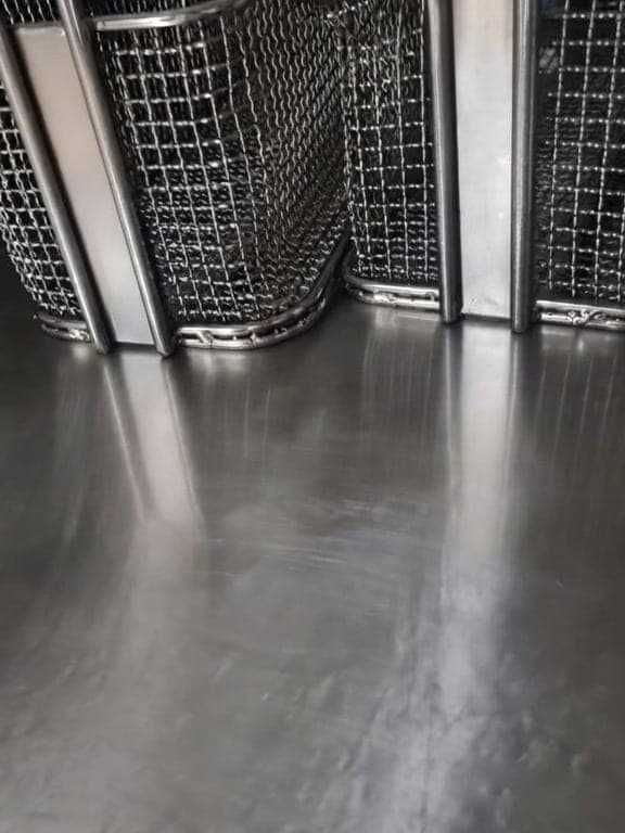 Sol inox brillant sous des paniers de friteuse dans une cuisine de restaurant, plan propre et net
