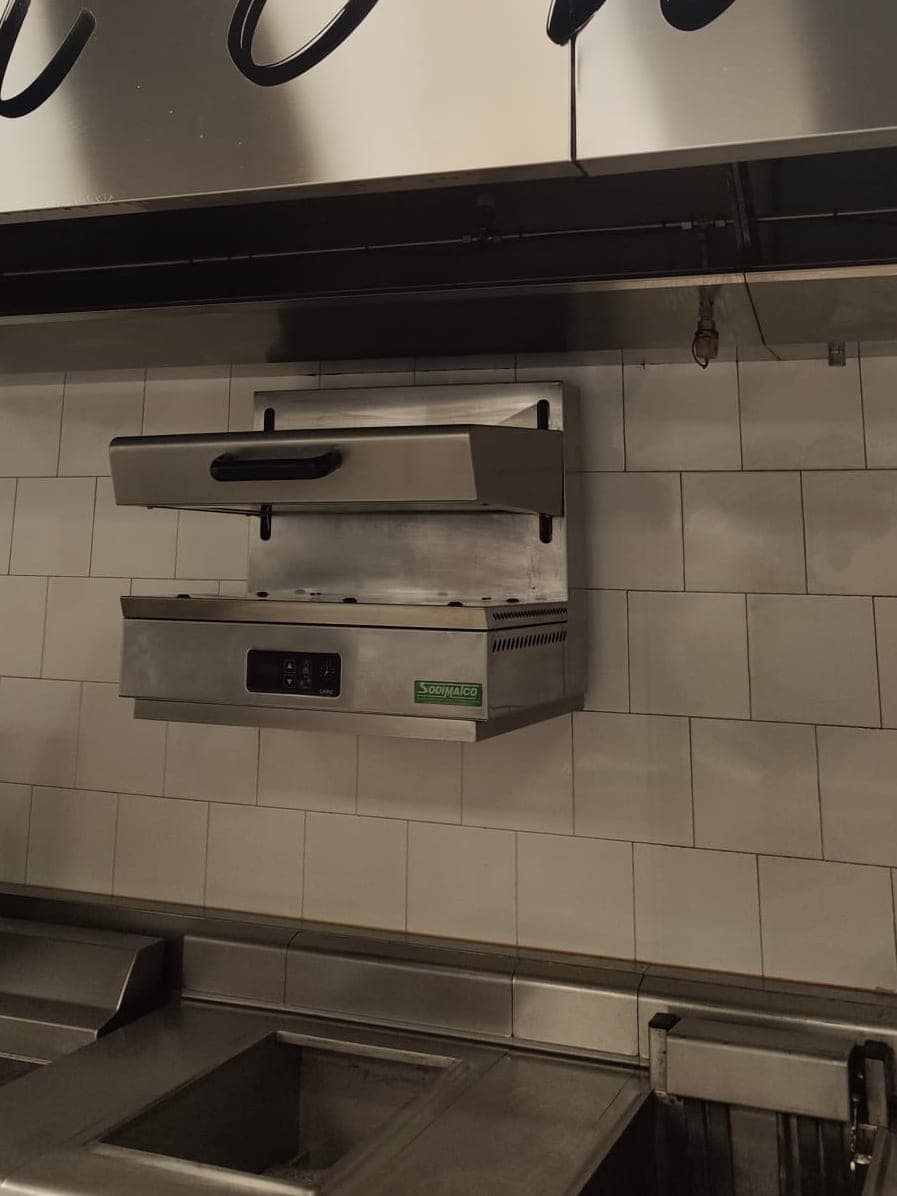 Hotte, salamandre et friteuses d'une cuisine de restaurant, inox brillant