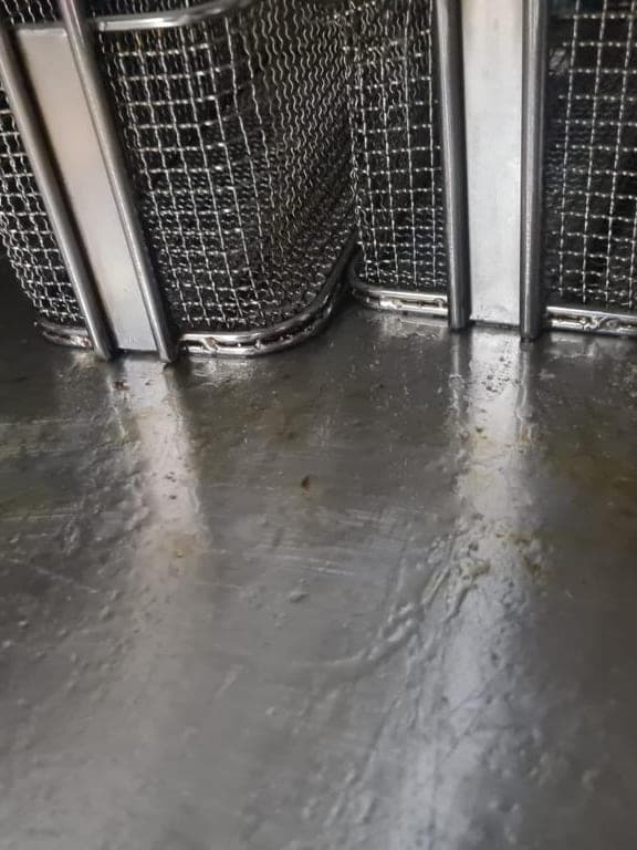 Fond de friteuse et paniers couverts de graisse et de résidus