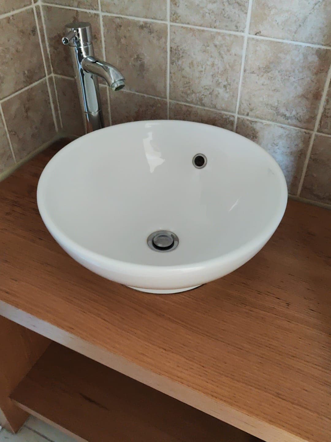 Vasque blanche et meuble en bois d'une salle d'eau propre