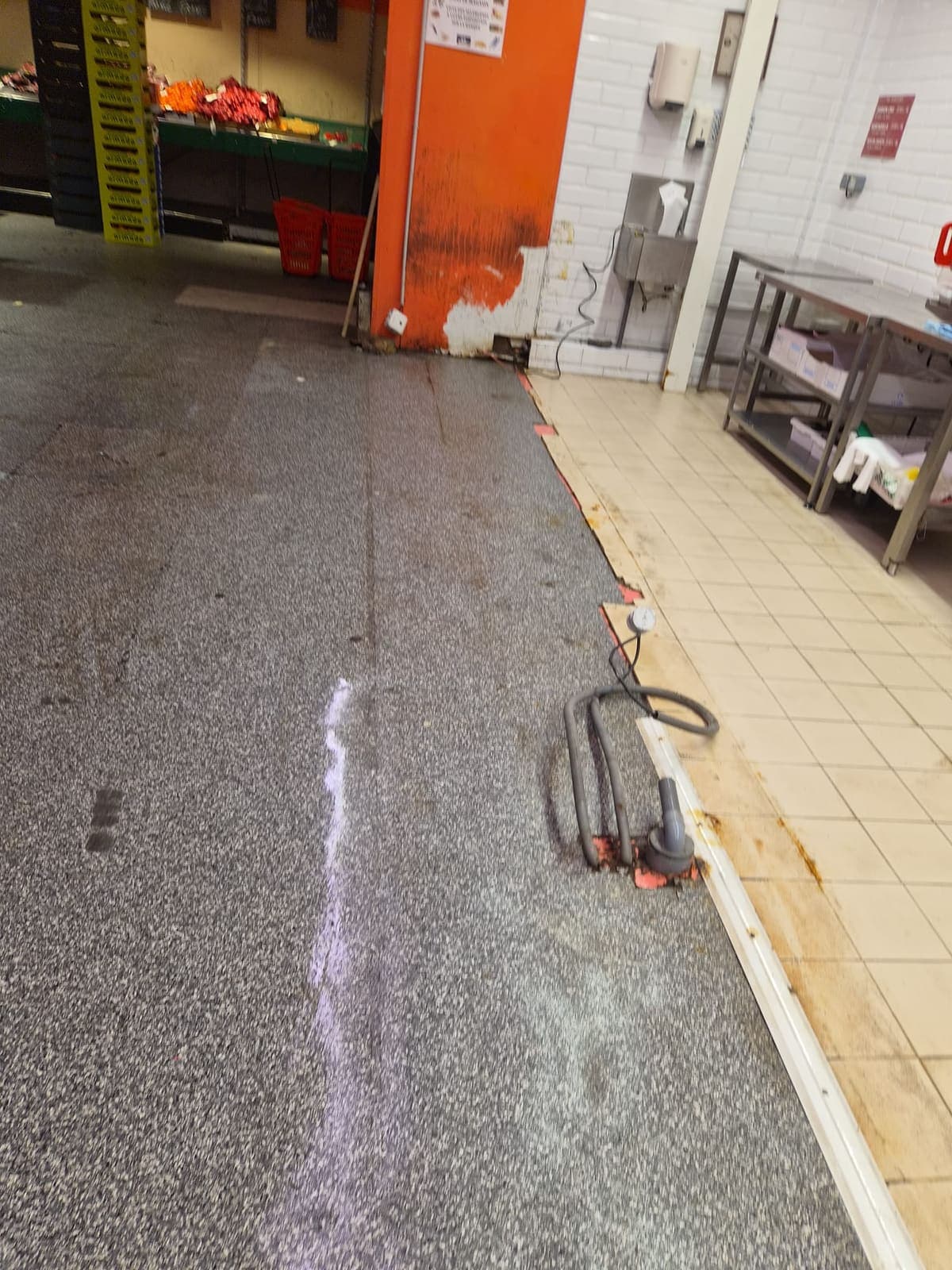 Surface de vente au rayon fruits, sol gris et carrelage, câble d'autolaveuse au sol
