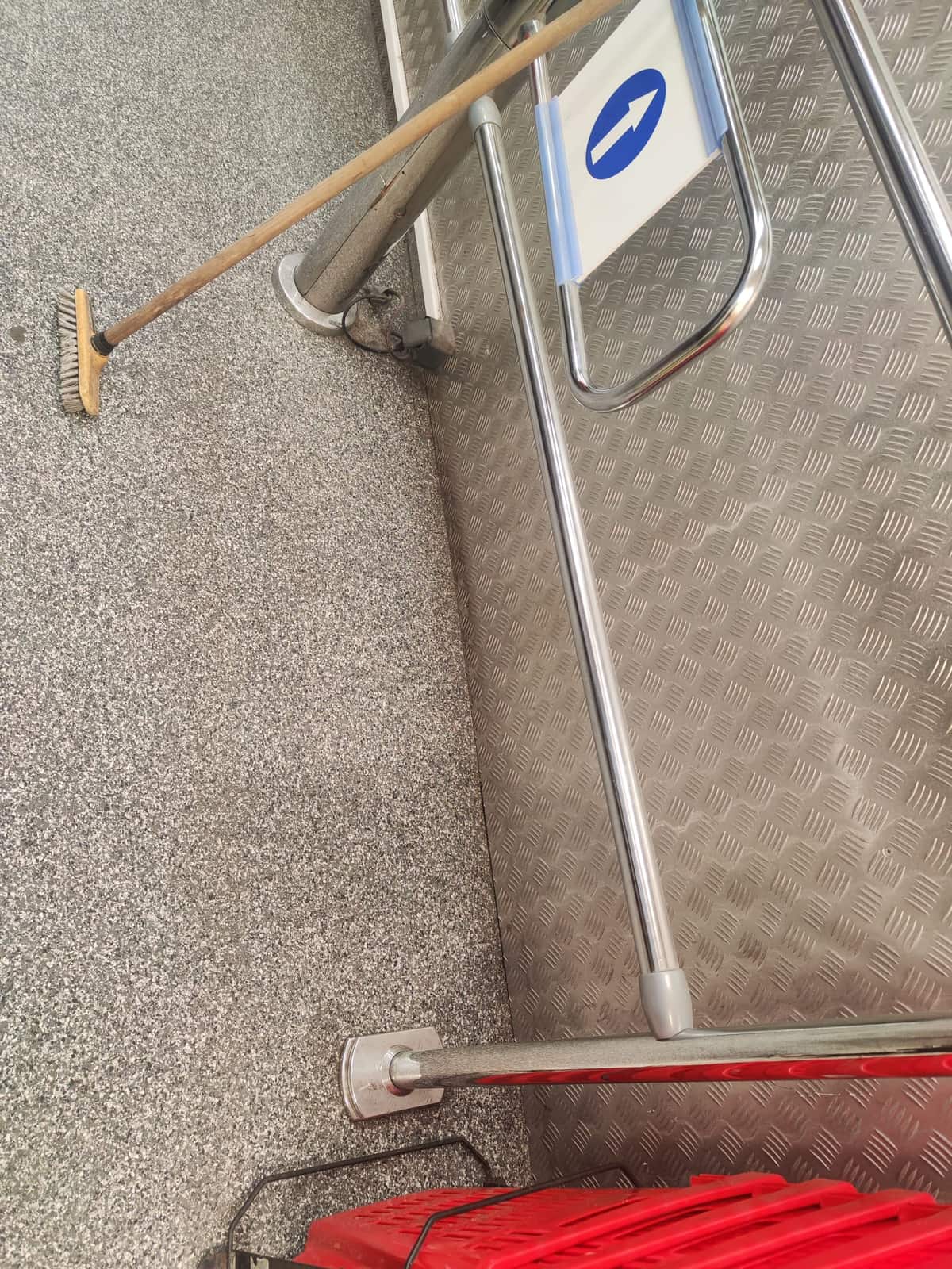 Sol en granito, balai, barrière inox et panneau fléché